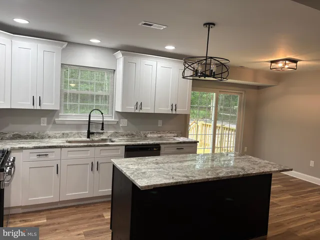 a kitchen with granite countertop a sink cabinets and window