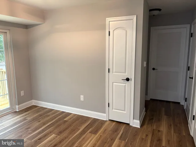an empty room with wooden floor and a window