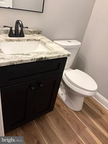 a bathroom with a granite countertop toilet sink and mirror
