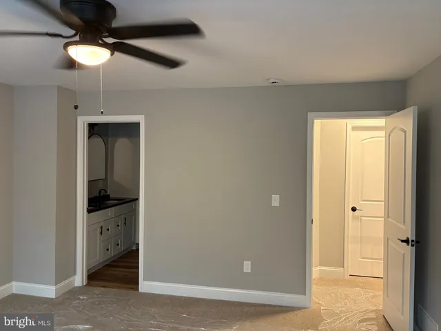 a view of a hallway with closet and a chandelier fan