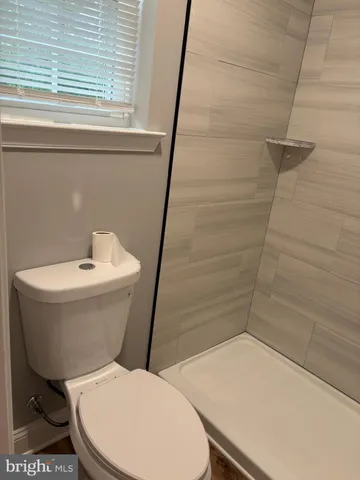 a white toilet sitting next to a bath tub