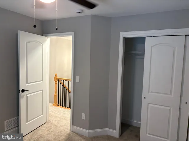 a view of a hallway with wooden floor and cabinet
