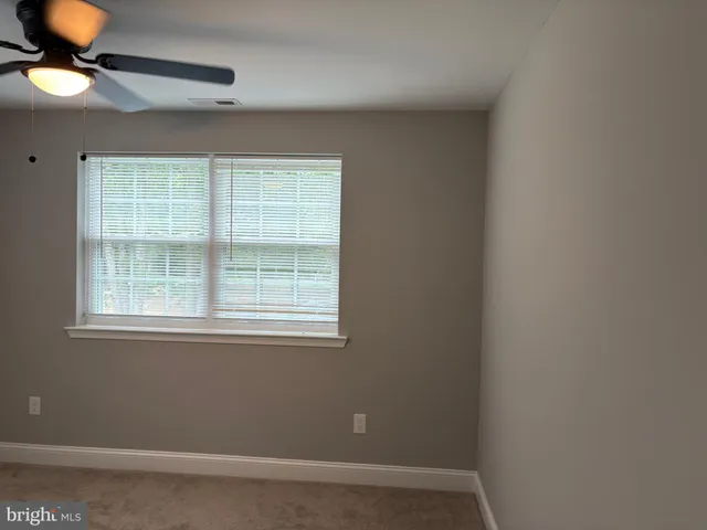 an empty room with window and fan