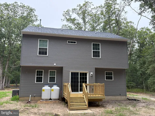 a front view of a house with a tree