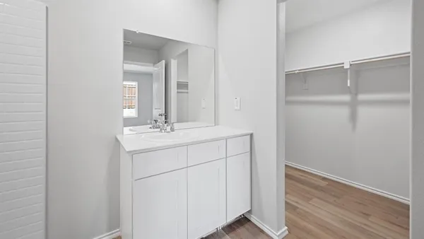 an empty room with wooden floor & windows