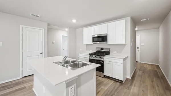 a kitchen with a sink a stove and cabinets