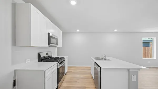 a kitchen with sink a microwave a stove and refrigerator