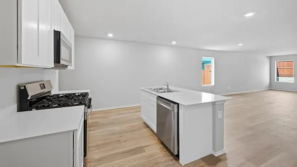 a kitchen with stainless steel appliances a sink stove and refrigerator