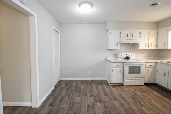 a kitchen with white cabinets and white appliances