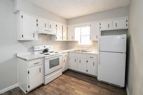 a kitchen with cabinets appliances a sink and a window