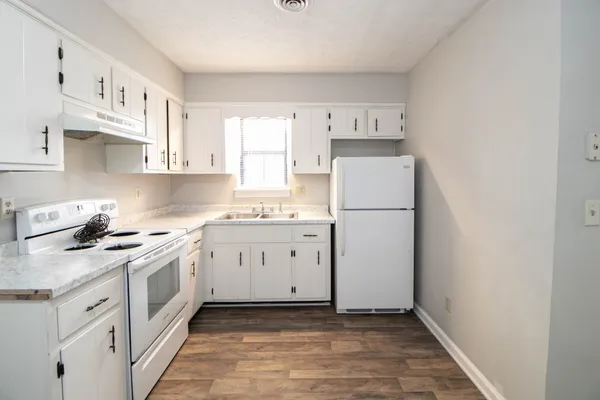 a kitchen with white cabinets and white appliances