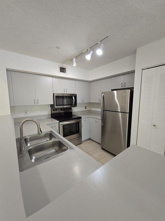12172 St Andrews Place, Unit 305 Miramar, FL 33025 - Photo 11 of 35 a kitchen with refrigerator a microwave and cabinets
