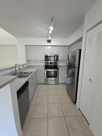 a kitchen with stainless steel appliances granite countertop a sink and stove top oven
