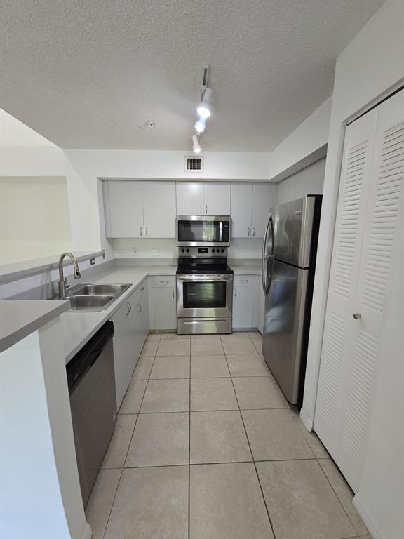 12172 St Andrews Place, Unit 305 Miramar, FL 33025 - Photo 12 of 35 a kitchen with granite countertop a refrigerator and a sink