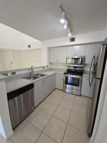 a kitchen with stainless steel appliances a refrigerator and a sink