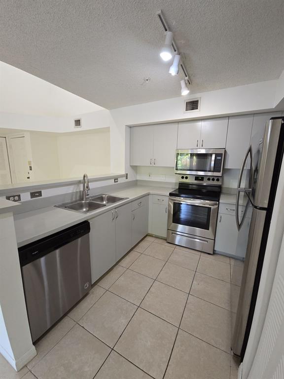 12172 St Andrews Place, Unit 305 Miramar, FL 33025 - Photo 13 of 35 a kitchen with stainless steel appliances granite countertop a sink and stove top oven