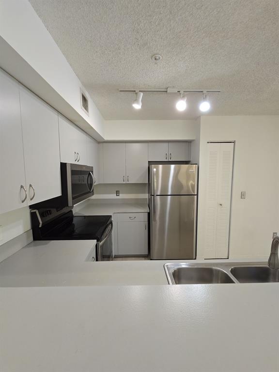 12172 St Andrews Place, Unit 305 Miramar, FL 33025 - Photo 14 of 35 a kitchen with stainless steel appliances a refrigerator and a sink