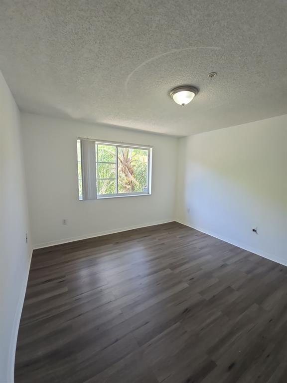 12172 St Andrews Place, Unit 305 Miramar, FL 33025 - Photo 32 of 35 an empty room with wooden floor and windows
