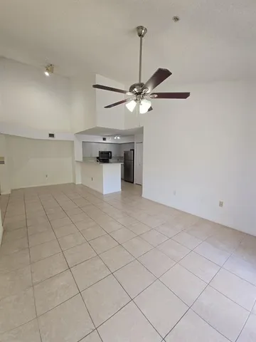 a view of a room with a chandelier fan and windows
