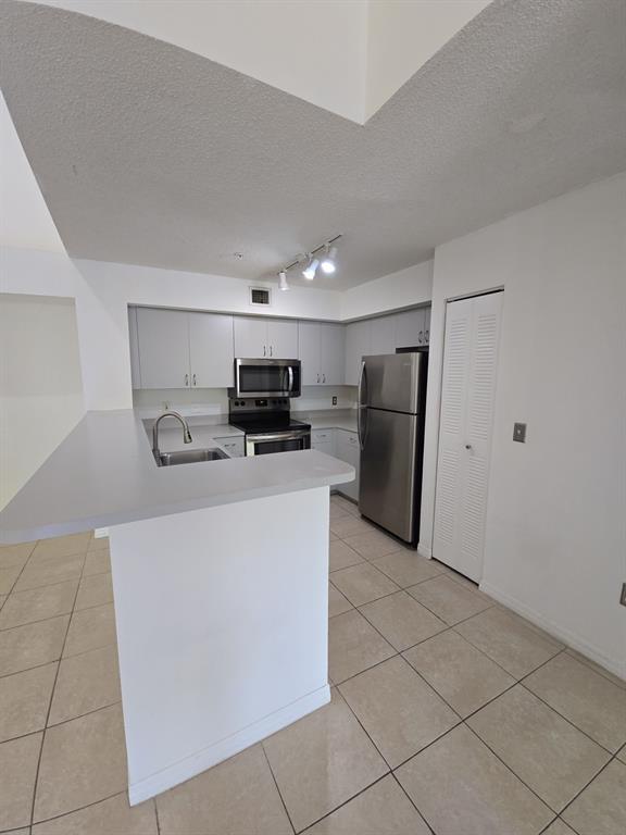 12172 St Andrews Place, Unit 305 Miramar, FL 33025 - Photo 10 of 35 a kitchen with stainless steel appliances a refrigerator and a stove top oven