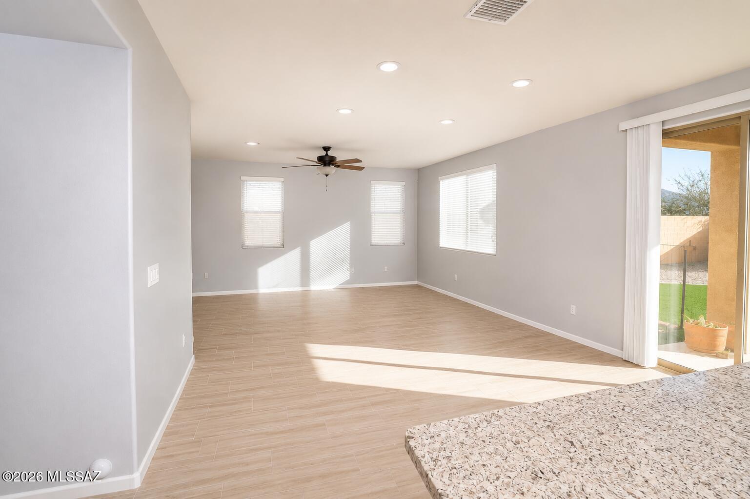 11484 East Desert Raptor Loop Tucson, AZ 85747 - Photo 2 of 28 a view of a room with a window and wooden floor