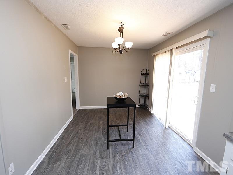 5912 Meadowbrook Road Raleigh, NC 27603 - Photo 5 of 12 a view of a livingroom with wooden floor and a ceiling fan