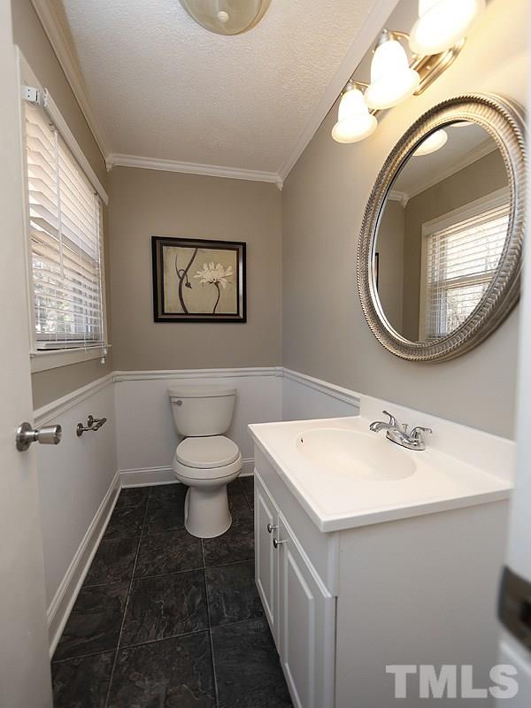 5912 Meadowbrook Road Raleigh, NC 27603 - Photo 7 of 12 a bathroom with a toilet a sink and a mirror