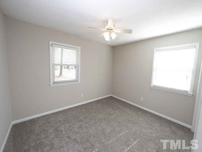 5912 Meadowbrook Road Raleigh, NC 27603 - Photo 8 of 12 an empty room with windows and fan