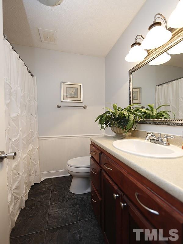 5912 Meadowbrook Road Raleigh, NC 27603 - Photo 10 of 12 a bathroom with a sink a toilet and a mirror