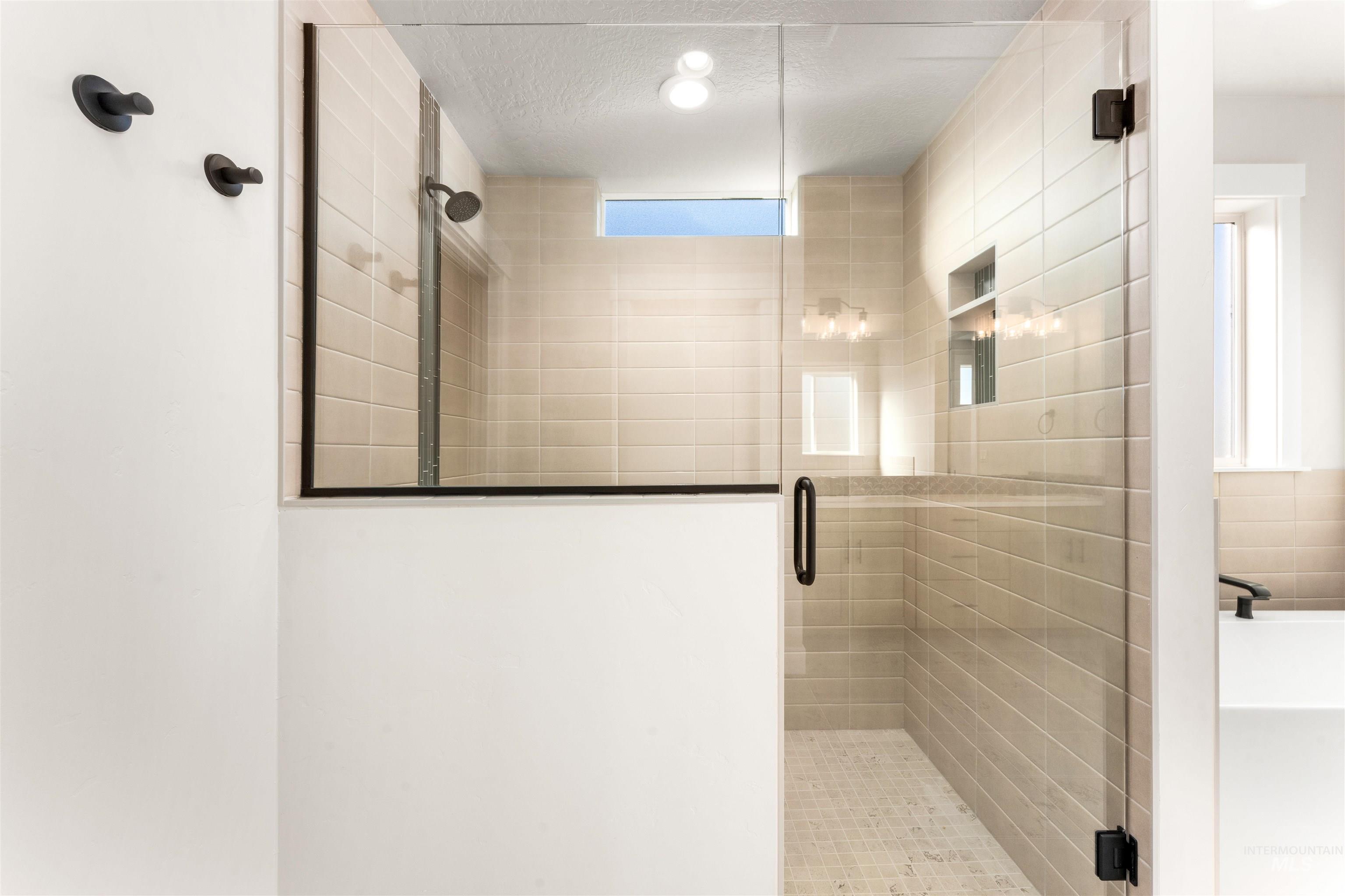 8084 Tandy Cv Street Middleton, ID 83644 - Photo 21 of 46 Bathroom with a shower stall, a textured ceiling, and a tub to relax in