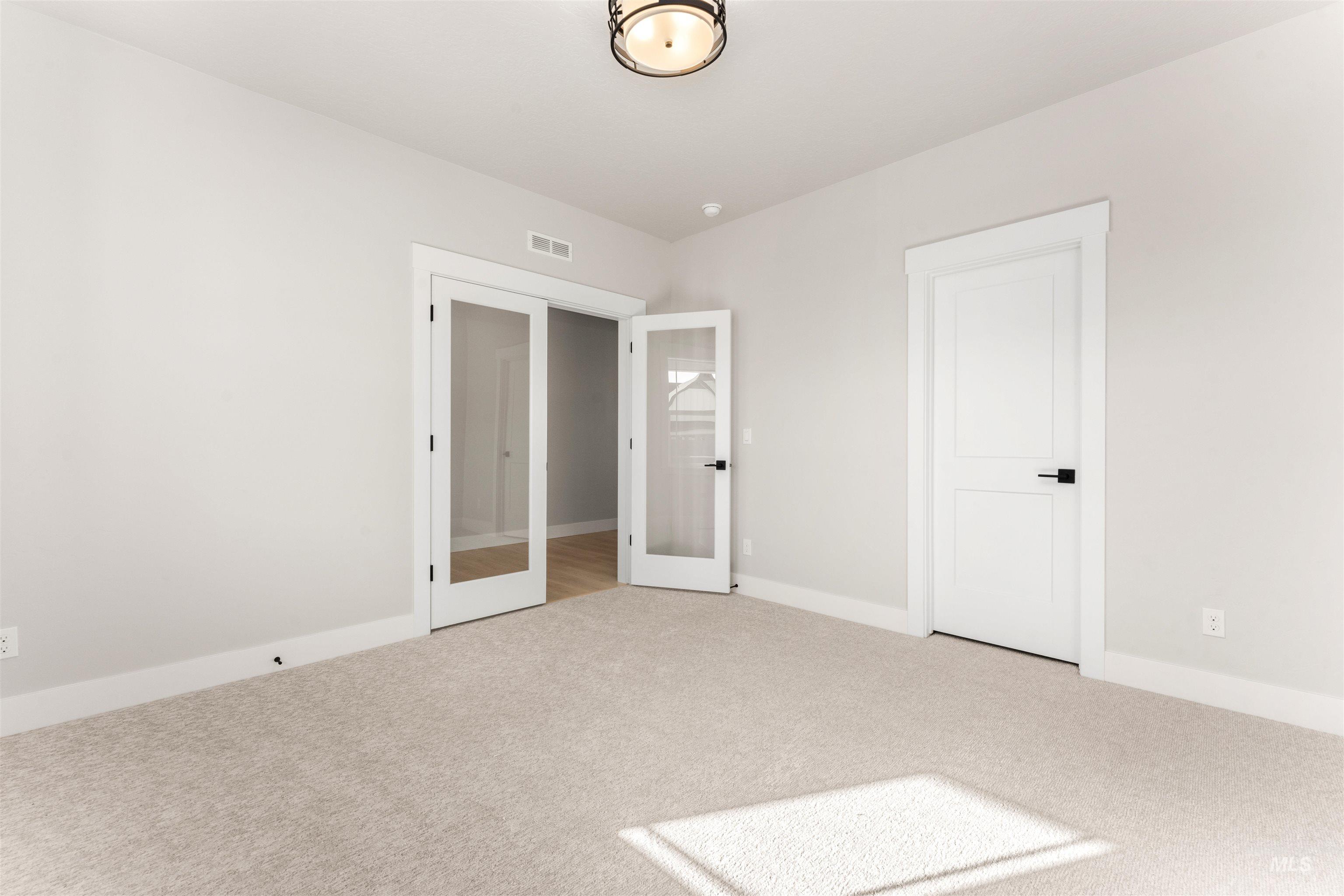 8084 Tandy Cv Street Middleton, ID 83644 - Photo 26 of 46 Unfurnished bedroom with french doors and light colored carpet