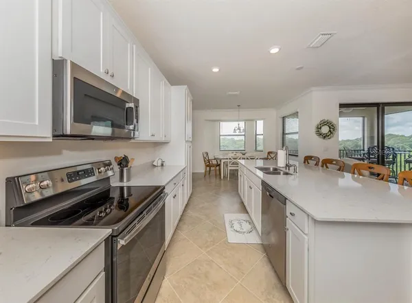 a kitchen with a sink a stove a refrigerator and white cabinets