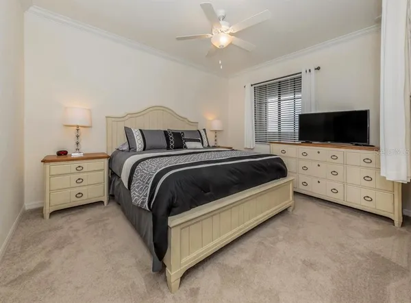 a spacious bedroom with a bed and a chandelier