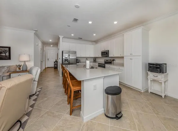 a large kitchen with stainless steel appliances granite countertop a lot of counter space and wooden floor