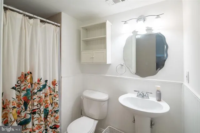 a bathroom with a sink toilet and mirror