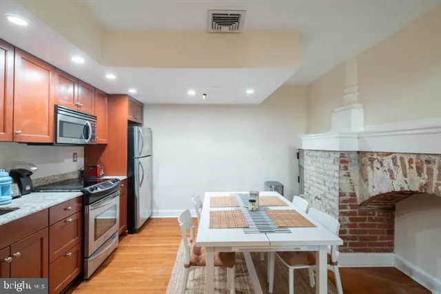 a kitchen with stainless steel appliances granite countertop a stove a sink and a refrigerator