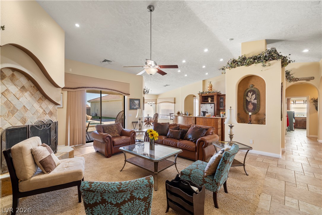 2181 Winery Road Pahrump, NV 89048 - Photo 11 of 52 A fireplace with decorative tile work anchors this living area, which connects to the outdoors via large sliding glass doors.