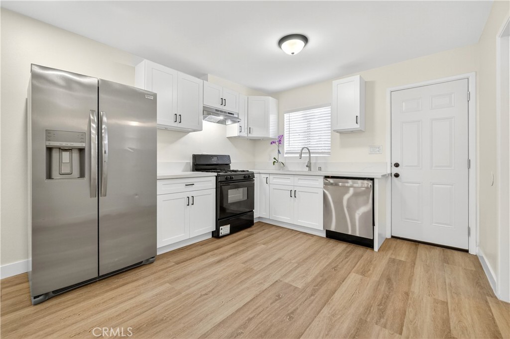 700 West Gonzales Road, Unit F Oxnard, CA 93036 - Photo 1 of 14 a kitchen with stainless steel appliances a sink cabinets and wooden floor