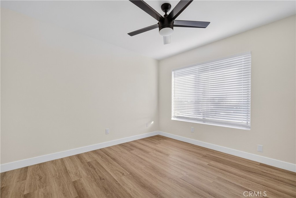 700 West Gonzales Road, Unit F Oxnard, CA 93036 - Photo 5 of 14 an empty room with wooden floor fan and windows