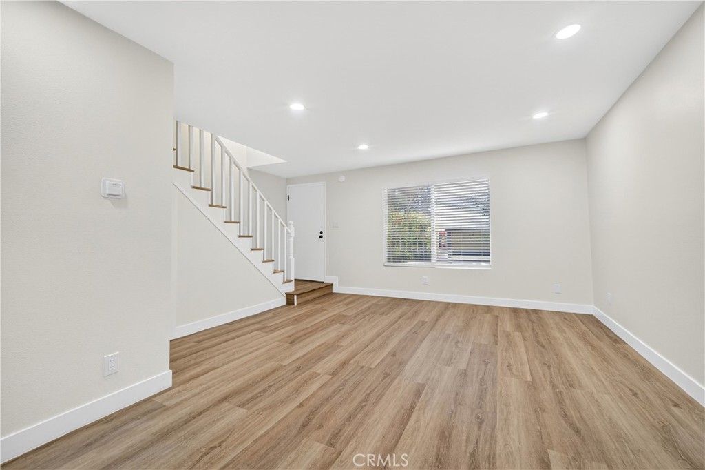 700 West Gonzales Road, Unit F Oxnard, CA 93036 - Photo 8 of 14 a view of an empty room with wooden floor and a window