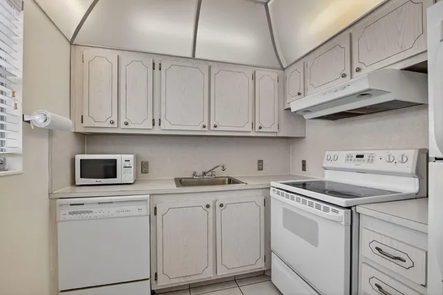 a kitchen with white cabinets and white appliances