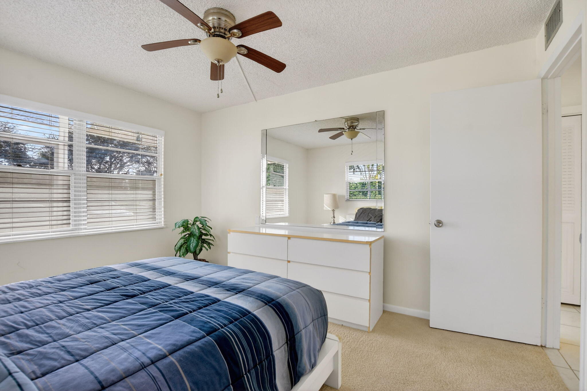 52 Mansfield B, Unit B Boca Raton, FL 33434 - Photo 15 of 49 a bedroom with a large bed and a chandelier fan