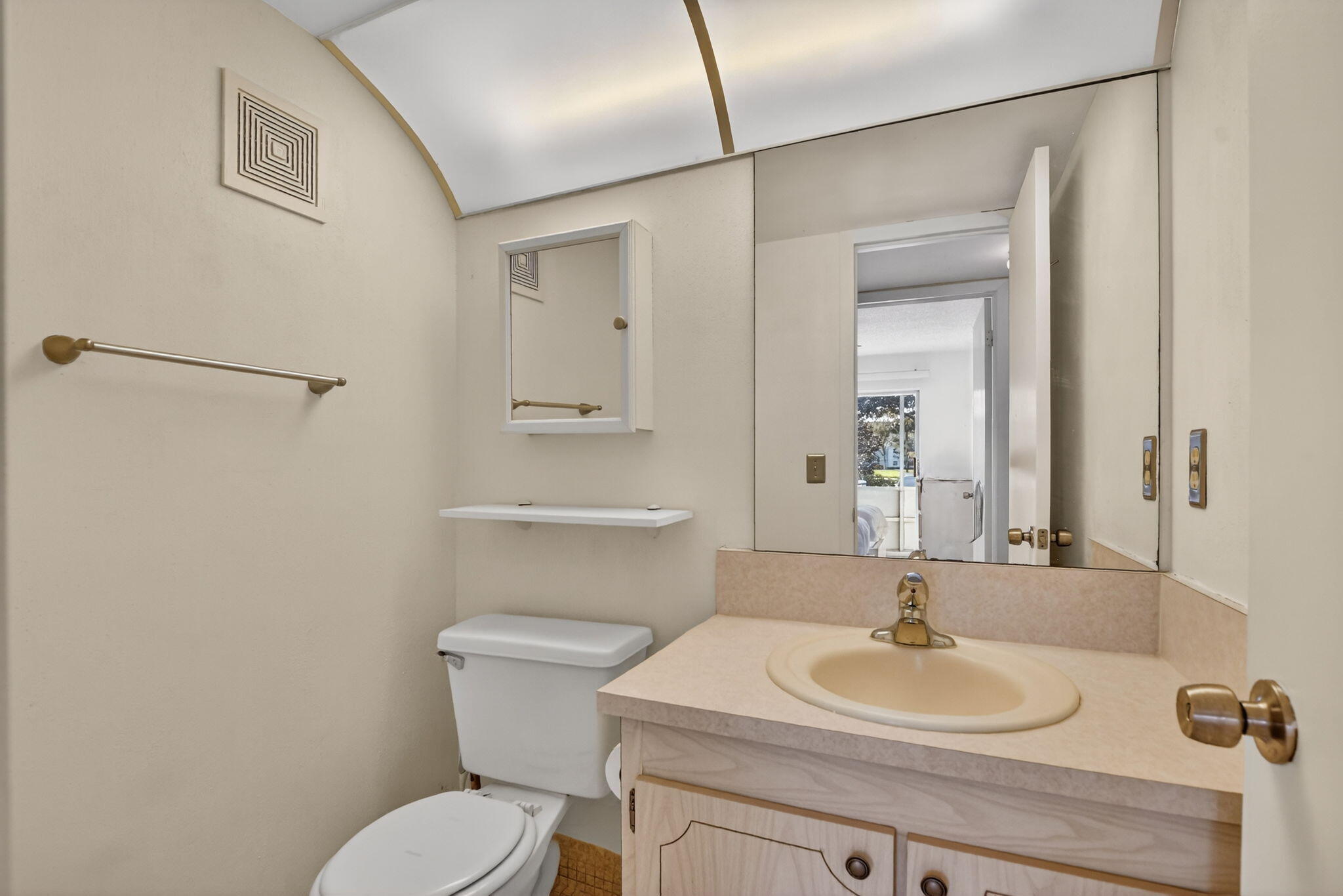 52 Mansfield B, Unit B Boca Raton, FL 33434 - Photo 20 of 49 a bathroom with a toilet sink a mirror and vanity