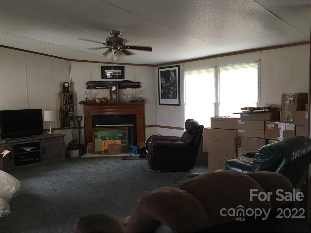 215 Linker Road Rockwell, NC 28138 - Photo 6 of 8 a living room with furniture a fireplace and a flat screen tv