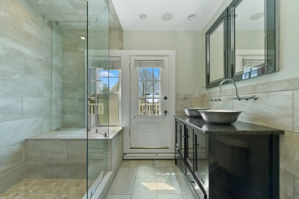 21 Beacon Road Hull, MA 02045 - Photo 20 of 40 a bathroom with a granite countertop sink a mirror and shower