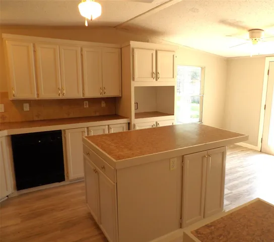 a kitchen with a sink cabinets and a wooden floor