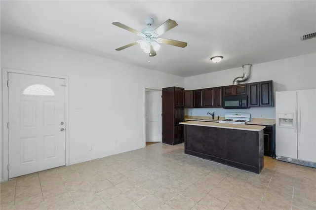 a view of kitchen with refrigerator and ceiling fan