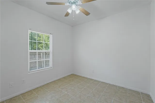 an empty room with a window and a fan