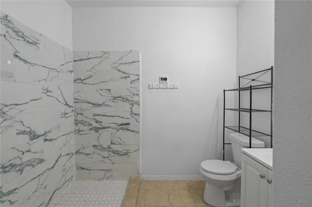 a white toilet sitting next to a shower