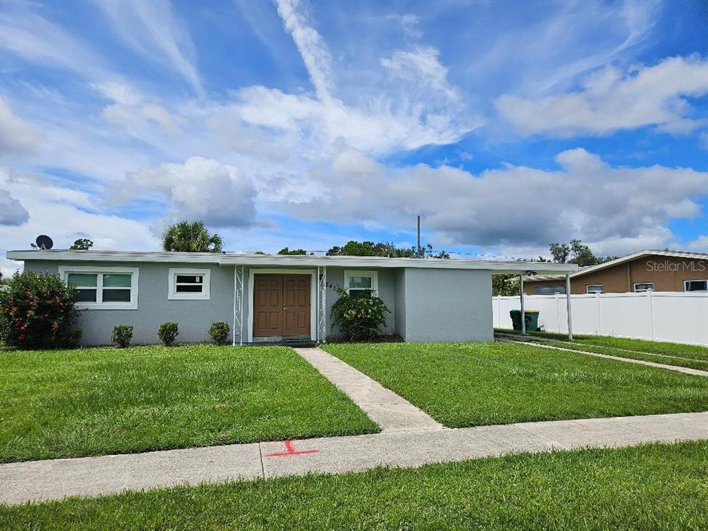2433 Ednor Street Port Charlotte, FL 33952 - Photo 1 of 1 a view of a white house in front of a big yard with potted plants and large trees